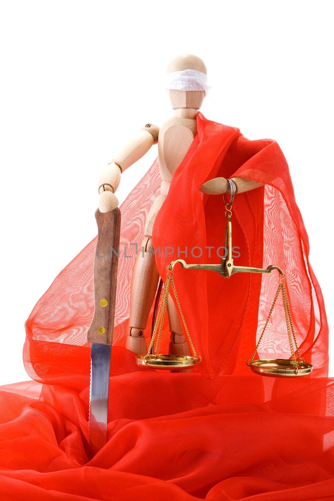 Wooden mannequin, a knife and scales on white background. The joke on the theme of Themis - Greek Goddess of Justice