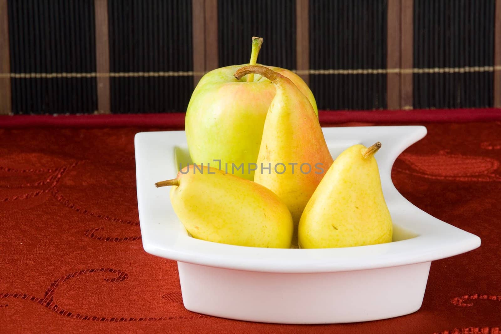 Sweet pears on a table covered with crimson cloth