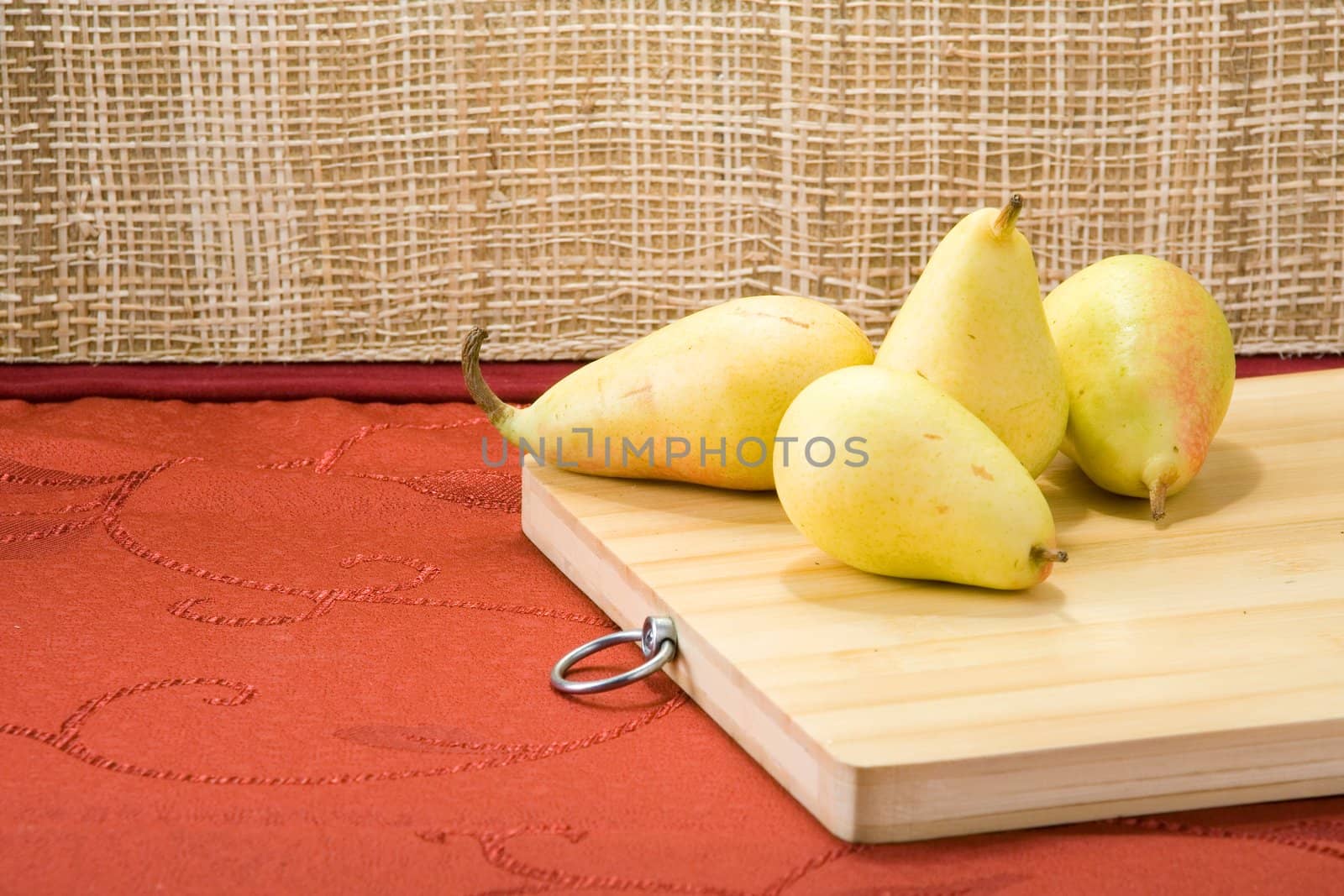 Sweet pears on a table covered with crimson cloth