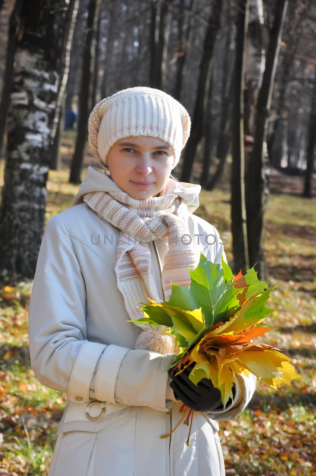 Young woman with a bouquet of maple leaves by jordano