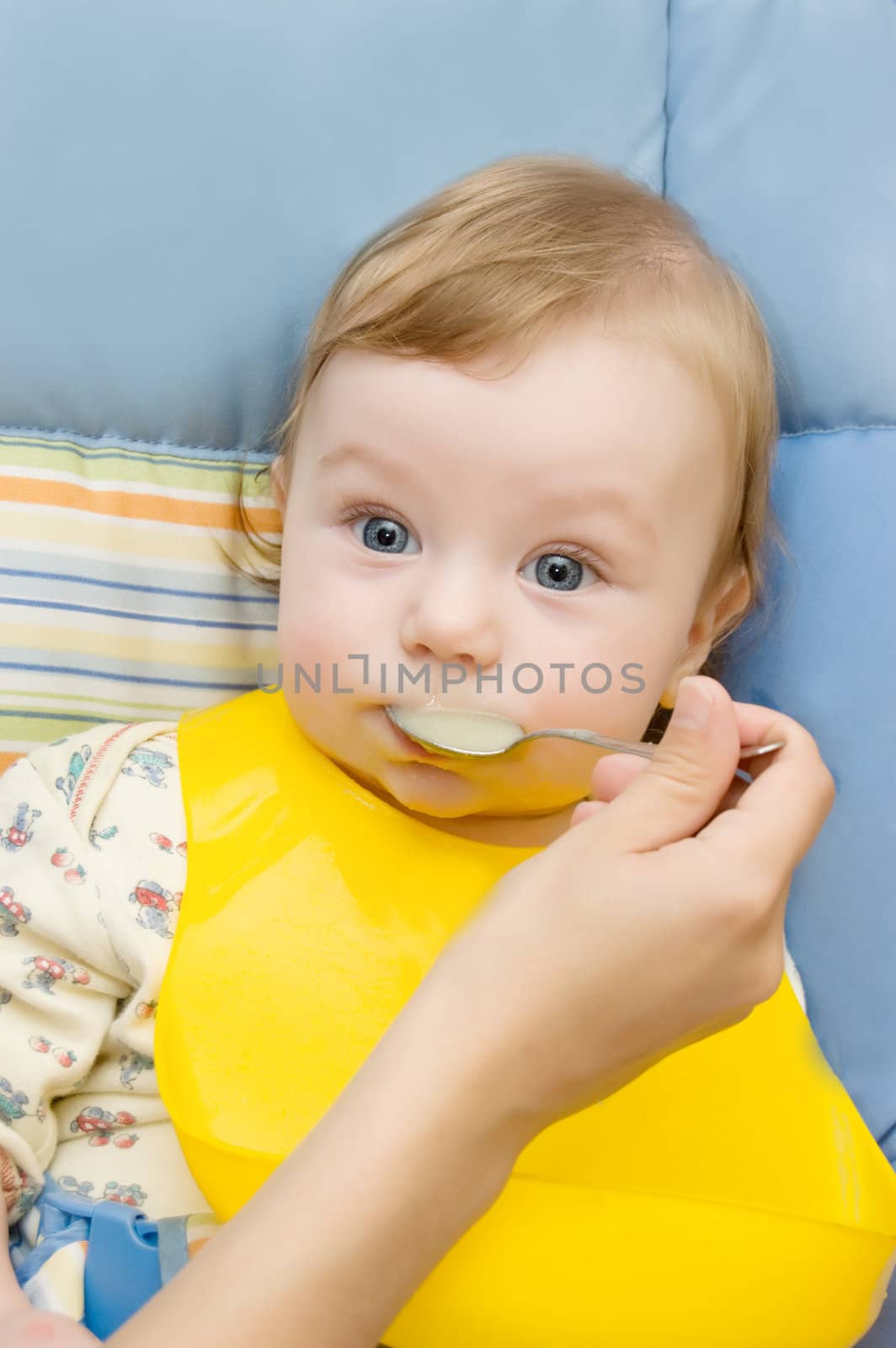 Mother's hand and baby boy eating