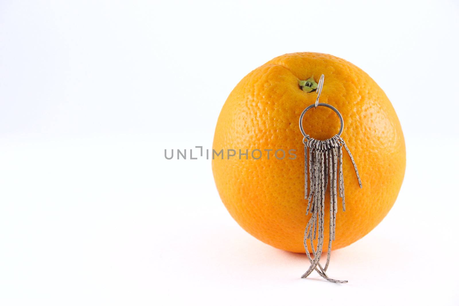 Orange with an earring removed on a white background close up. Not isolated