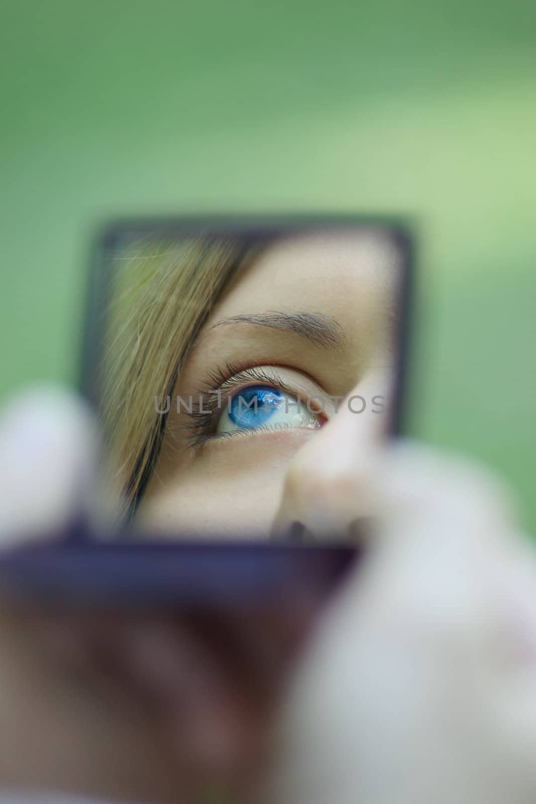 Female eye reflected in a mirror, removed in a sunny day