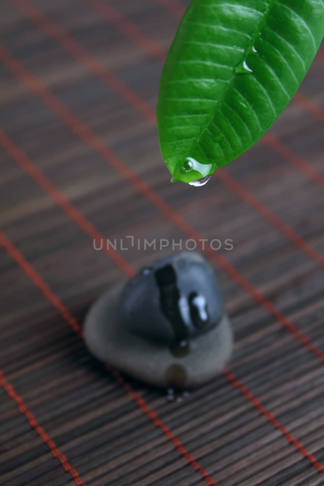 Stones for spa with green sheet on a bamboo napkin removed close up