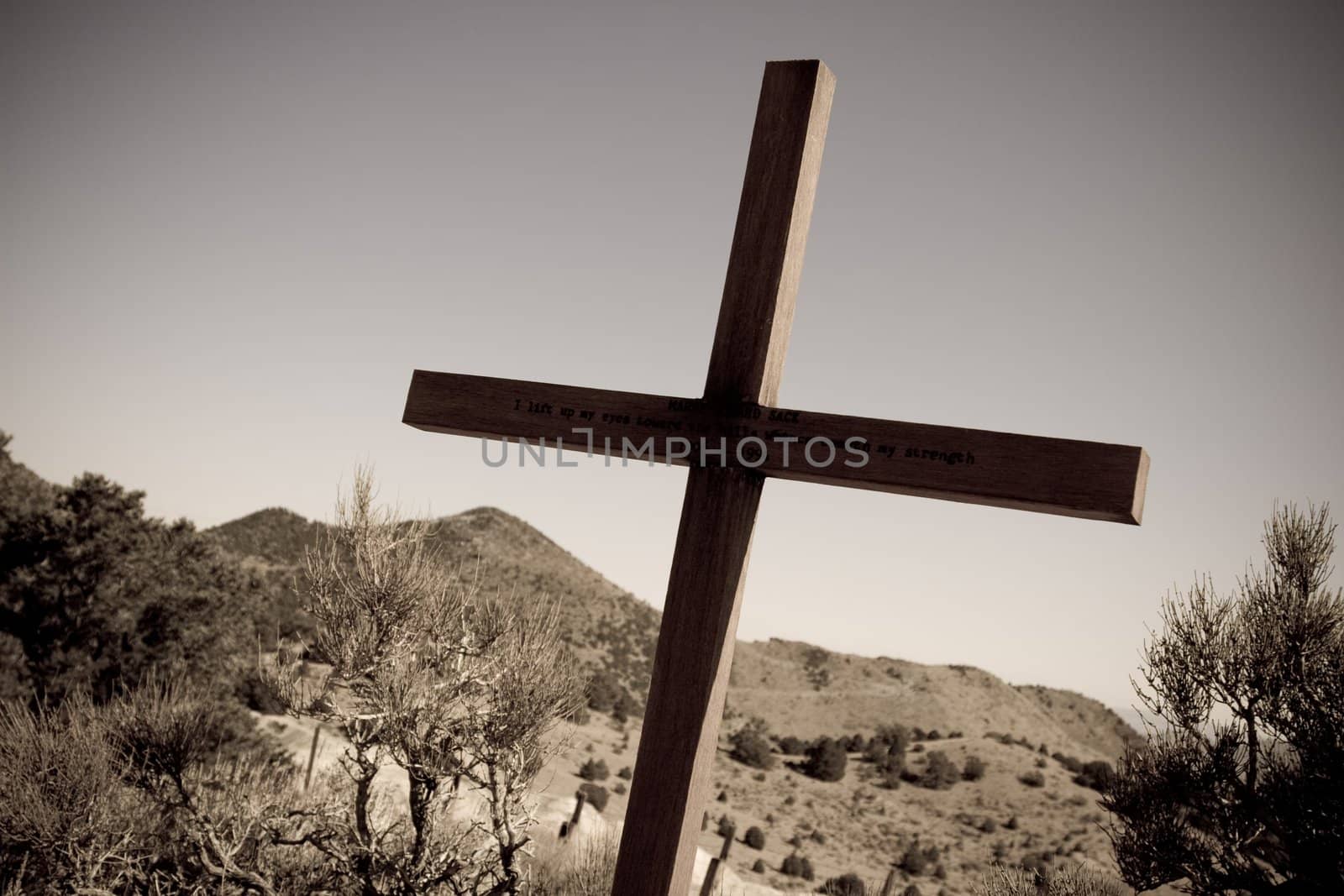 Sepia image of desert landscape and large wooden cross
