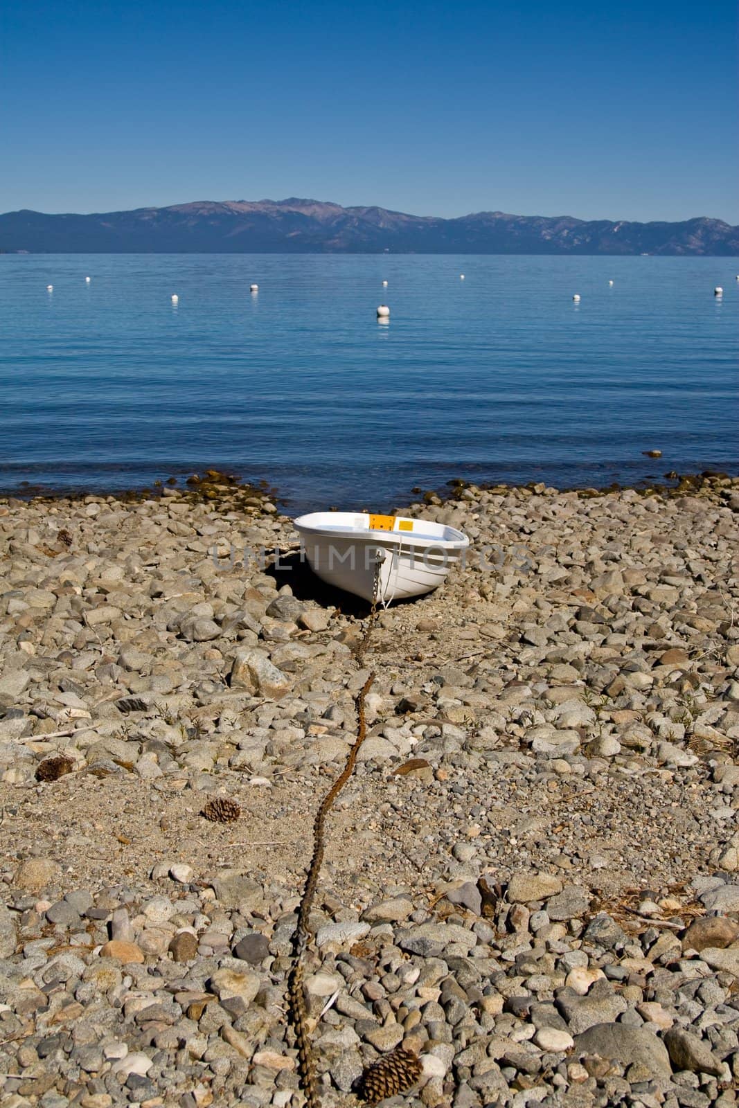 Landscape of boat chained to shore, mountains in background
