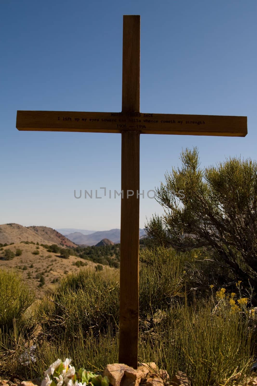 Large wooden grave marker in desert scrub landscape