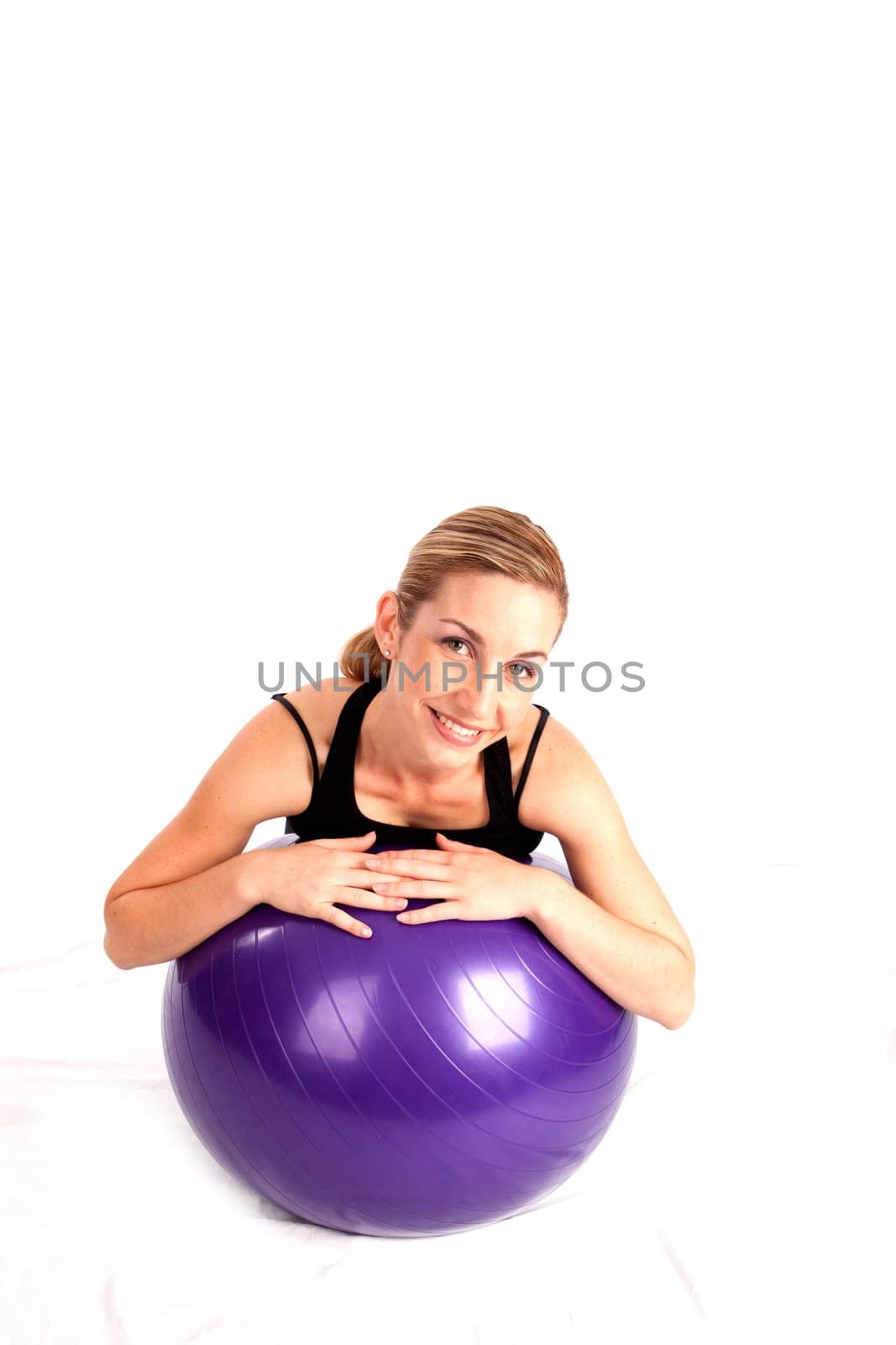Smiling young lady relaxing on yoga ball