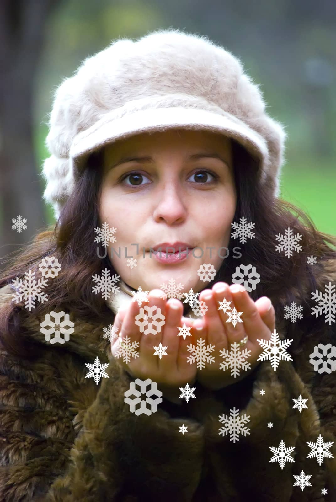 pretty girl blowing white snowflakes to the camera