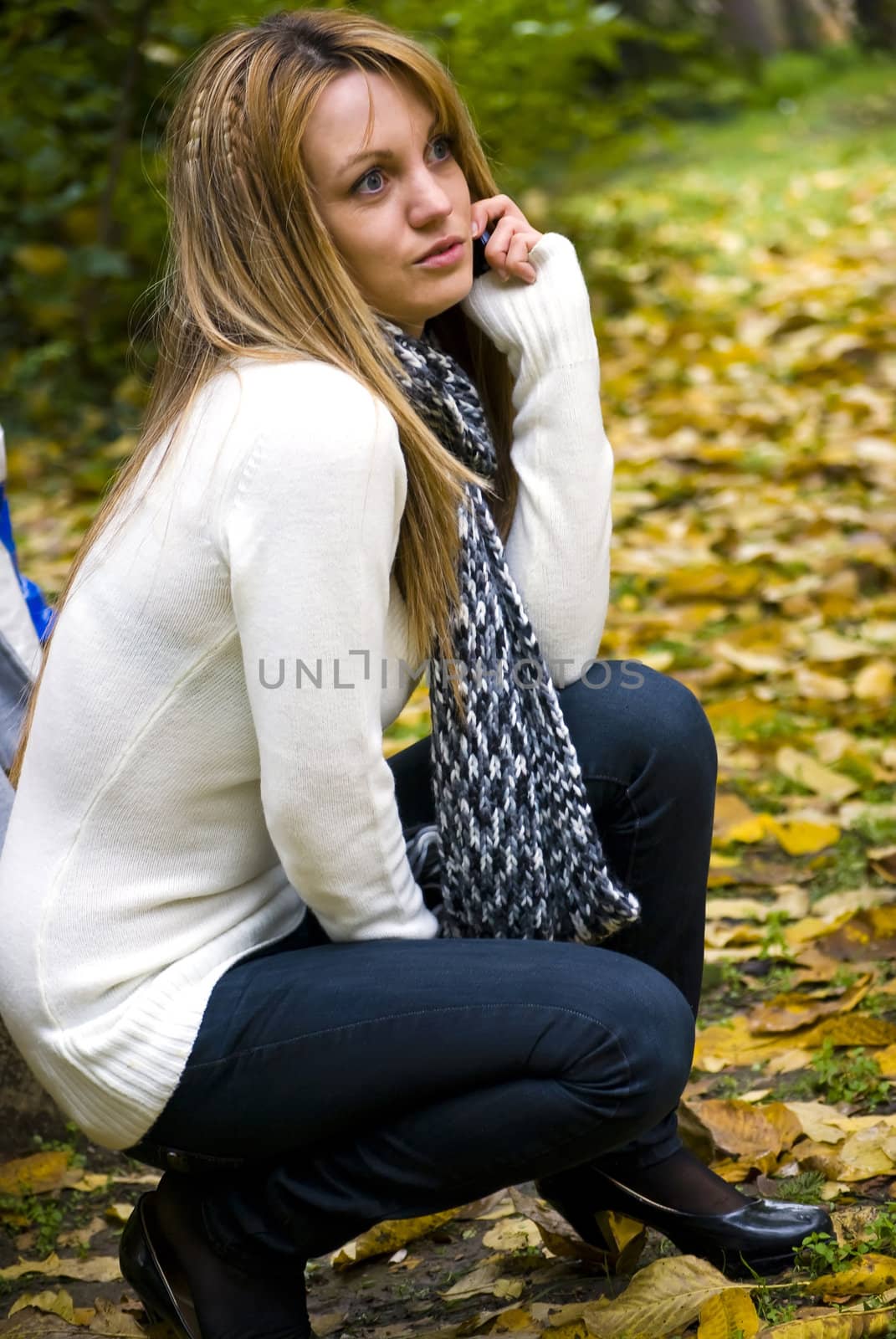 cute blond girl talking on phone outdoors in autumn