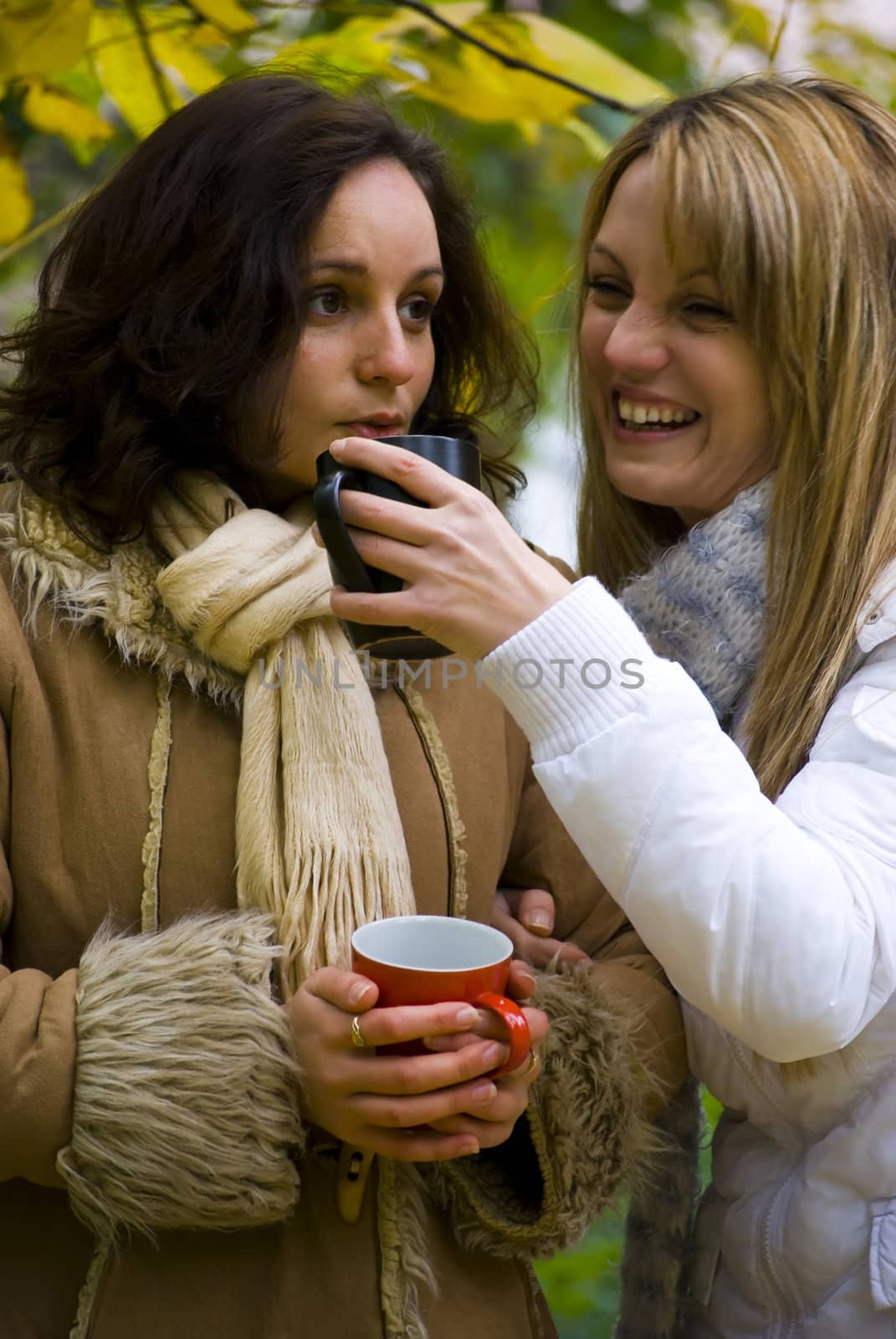 cute girls drinking hot tea in cold autumn