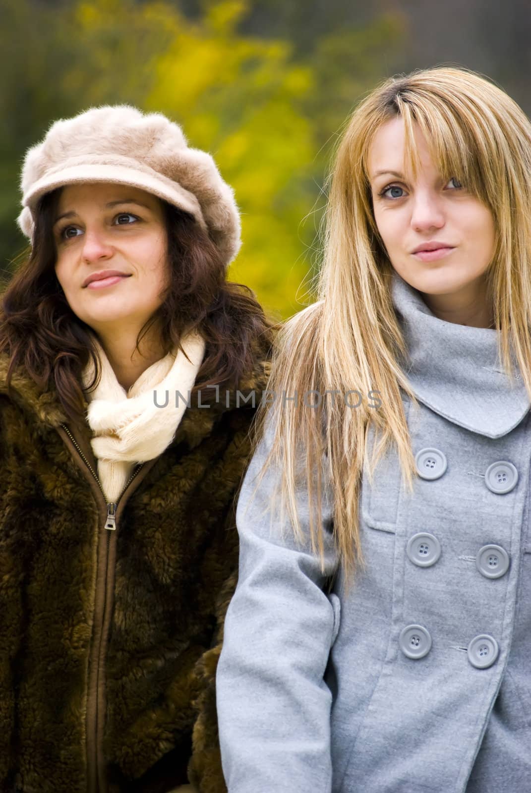 two cute girls walking in a park autumn