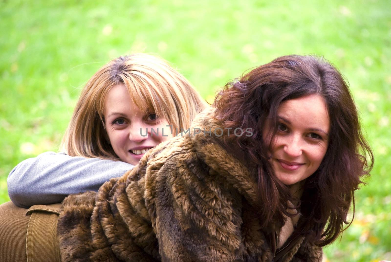 two beautiful young smiling women outdoors portrait in autumn