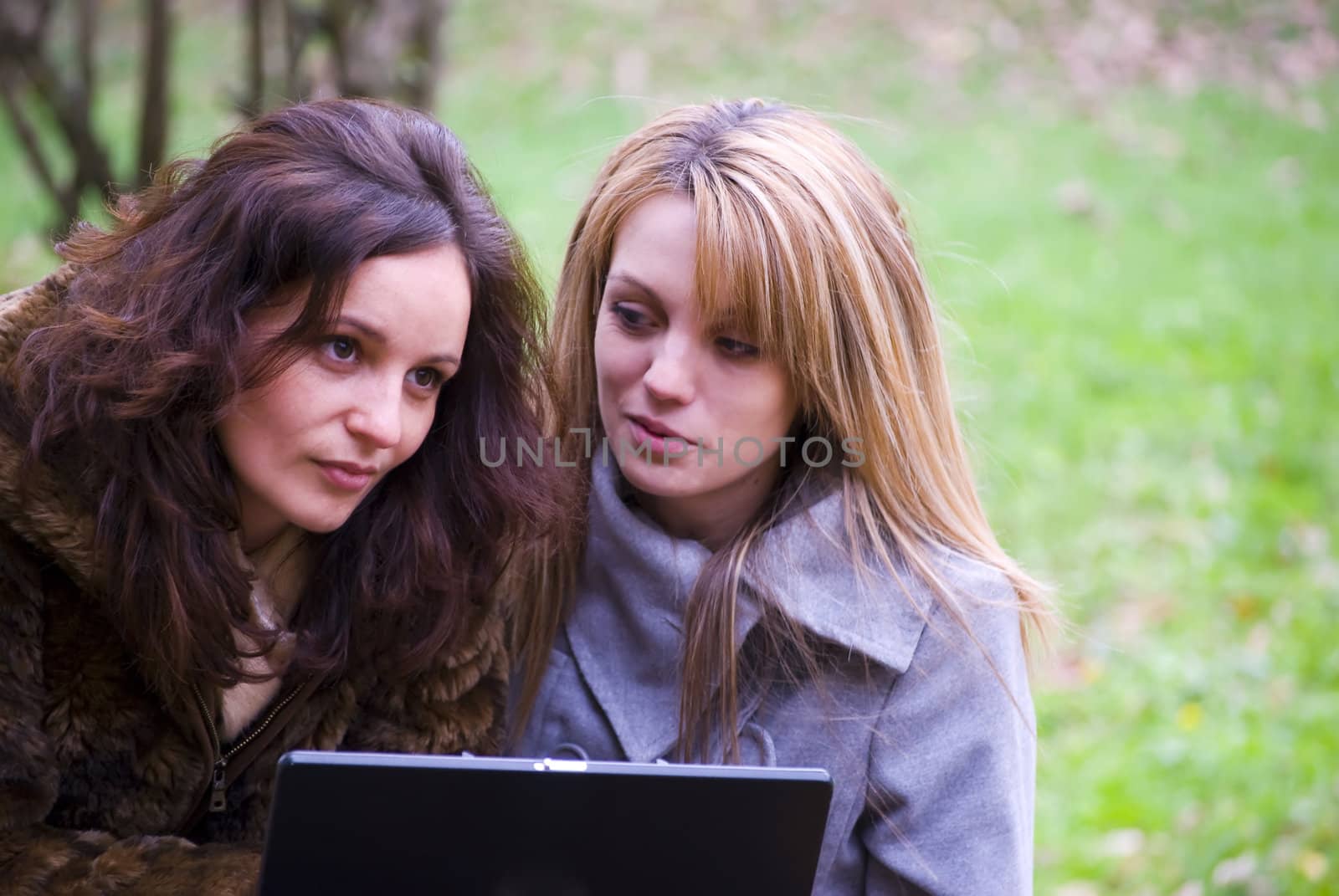 two students working out on laptop in autumn