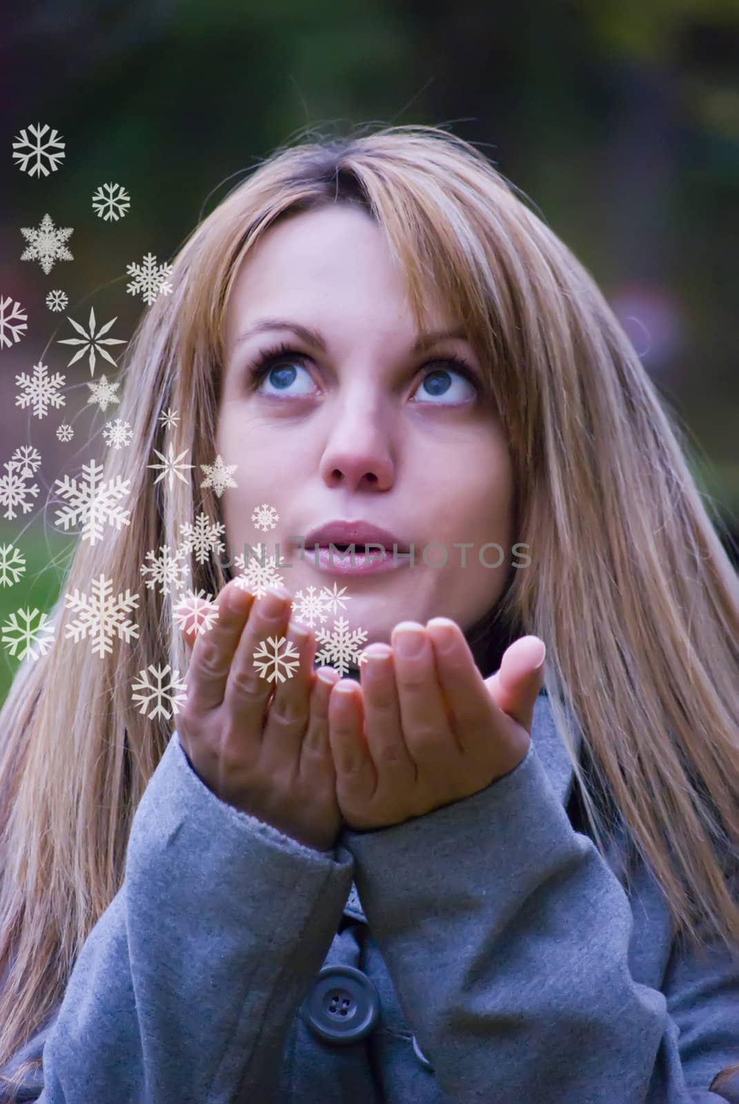 pretty girl blowing white snowflakes to the camera