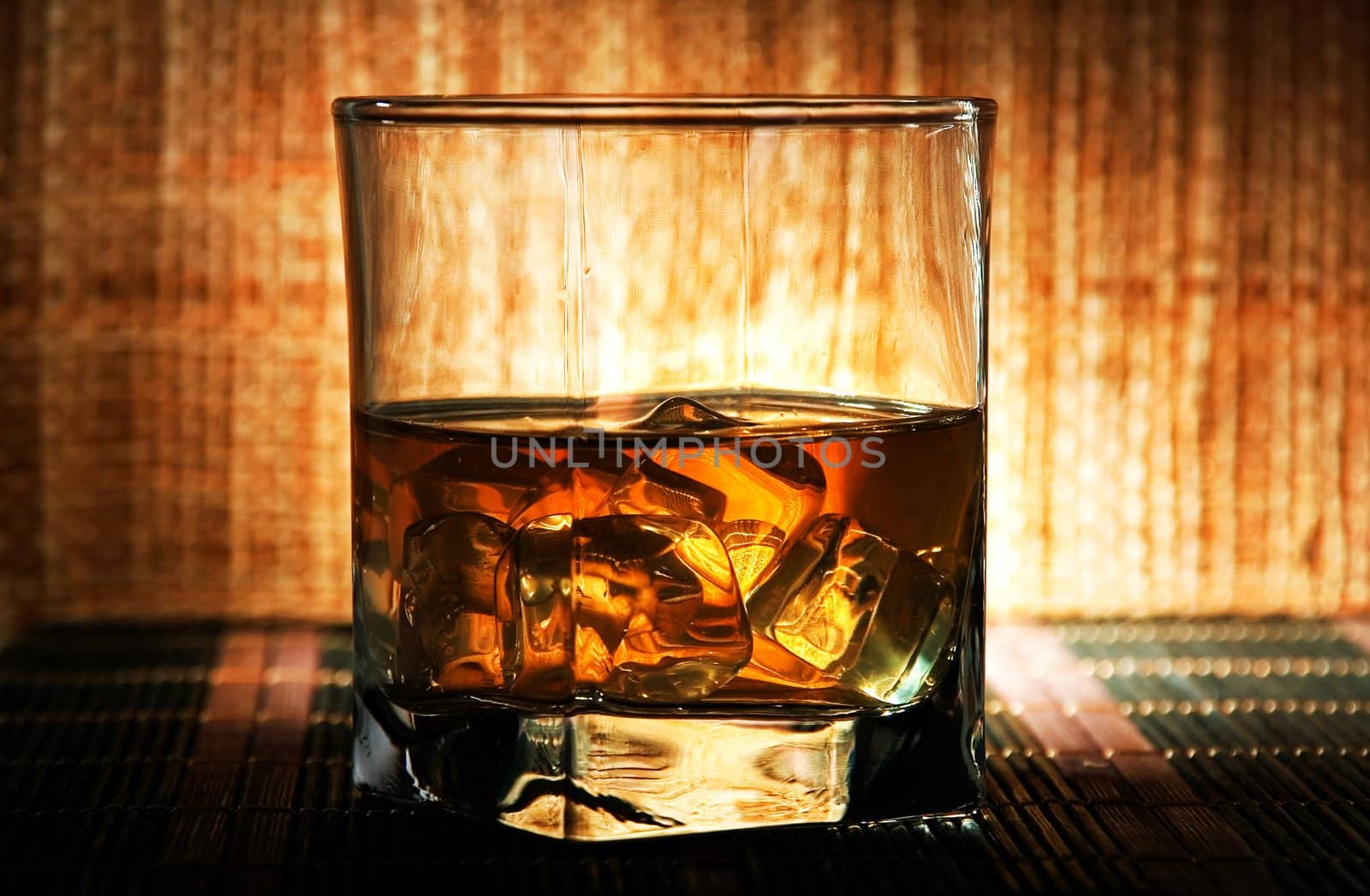 A glass of old whiskey on the rocks.