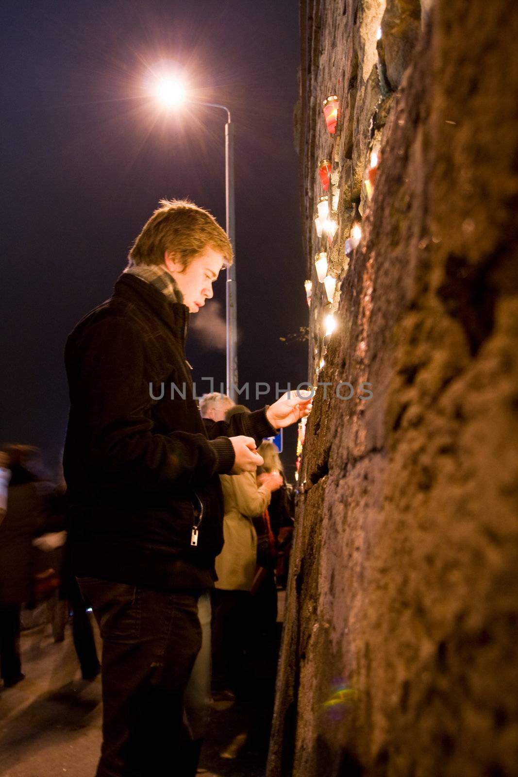 RIGA, LATVIA - NOVEMBER 11: Soldiers Memorial Day. Man lights candle at Prezident's castle wall to commemorate victory over the Russian and German militia. This victory was important in the birth of Latvia as an independent nation. November 11, 2009 in Riga
