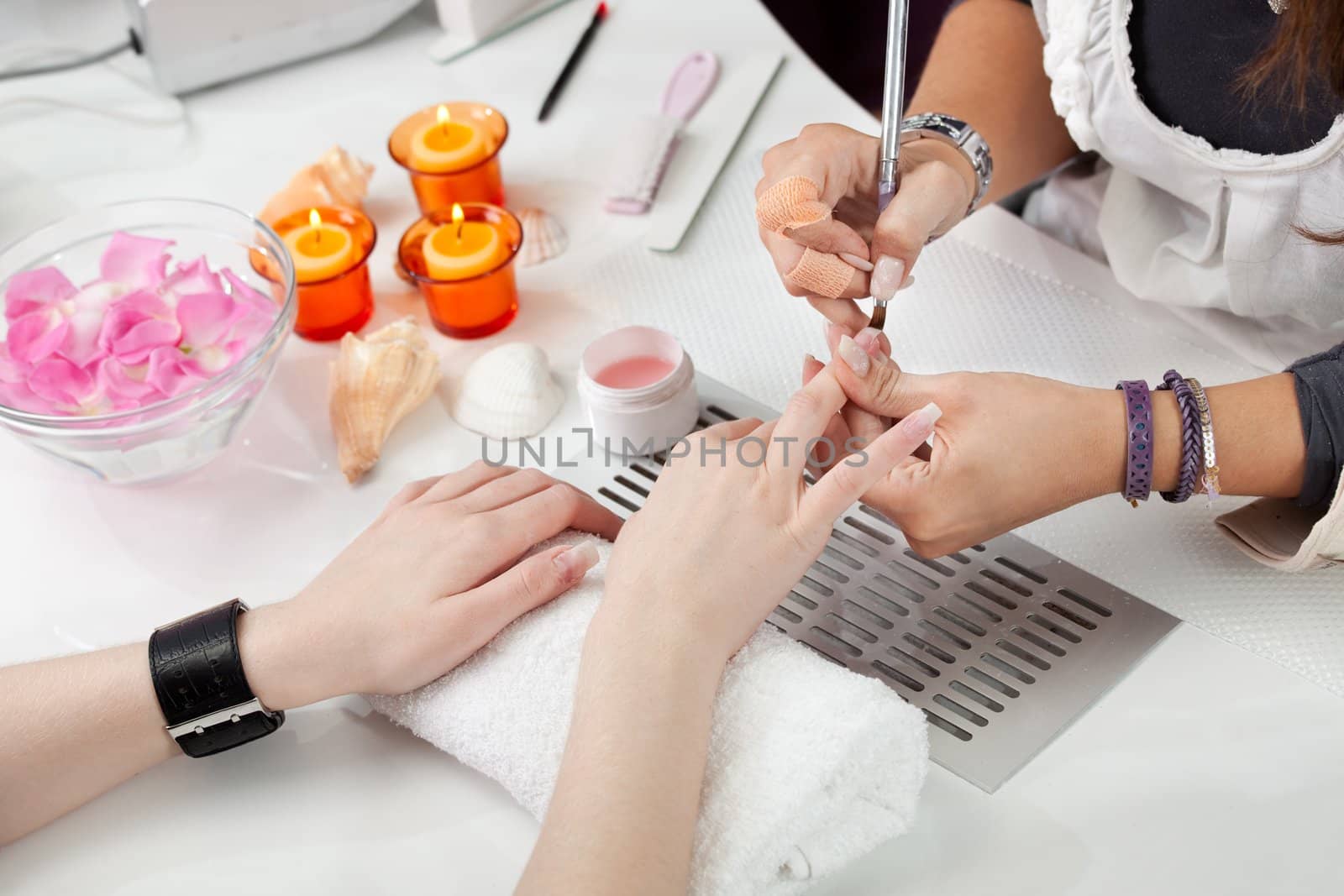 Beautician applying gel on fingernails. Close-up shot