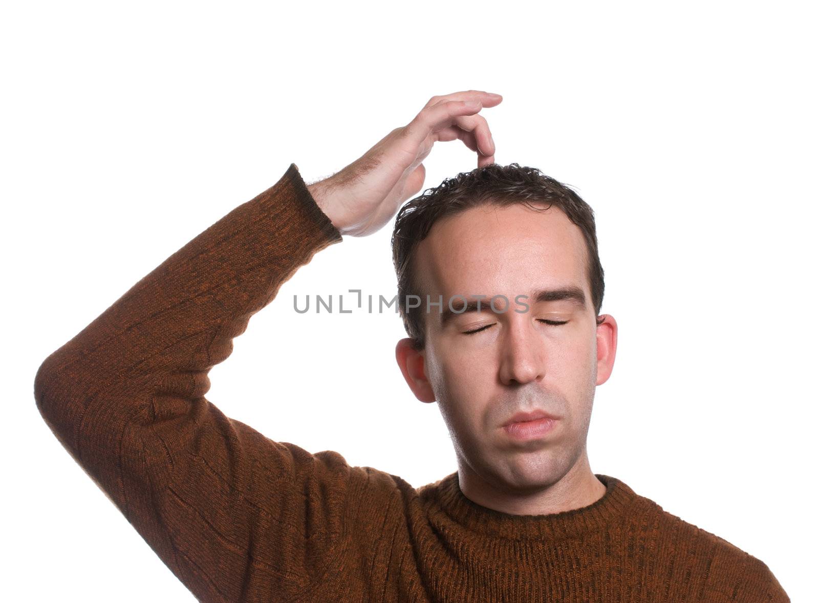 A man wearing a sweater is doing the "emotional freedom technique" by tapping on the top of his head, isolated against a white background