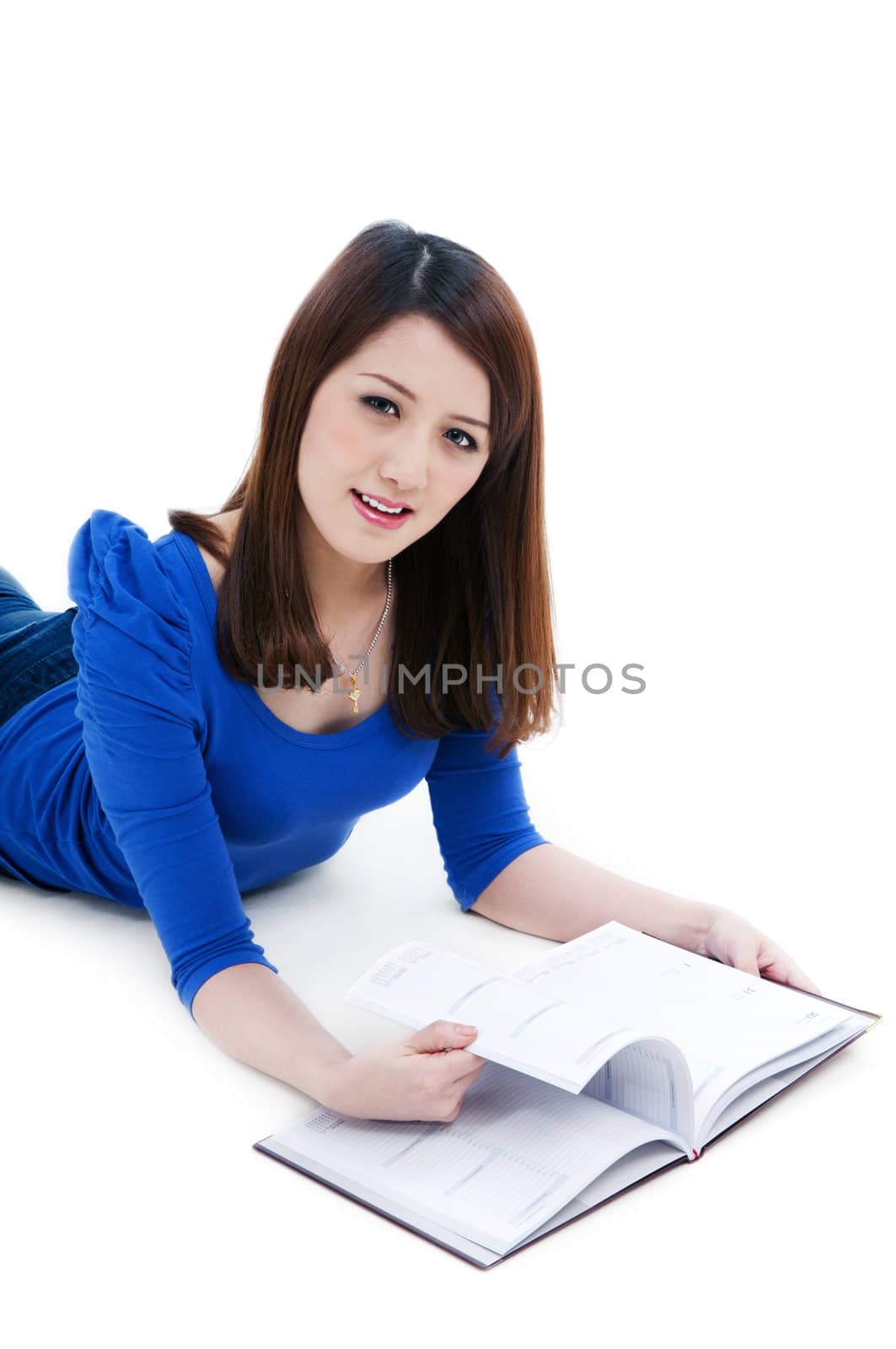 Portrait of a cute female student flipping her book over white background.