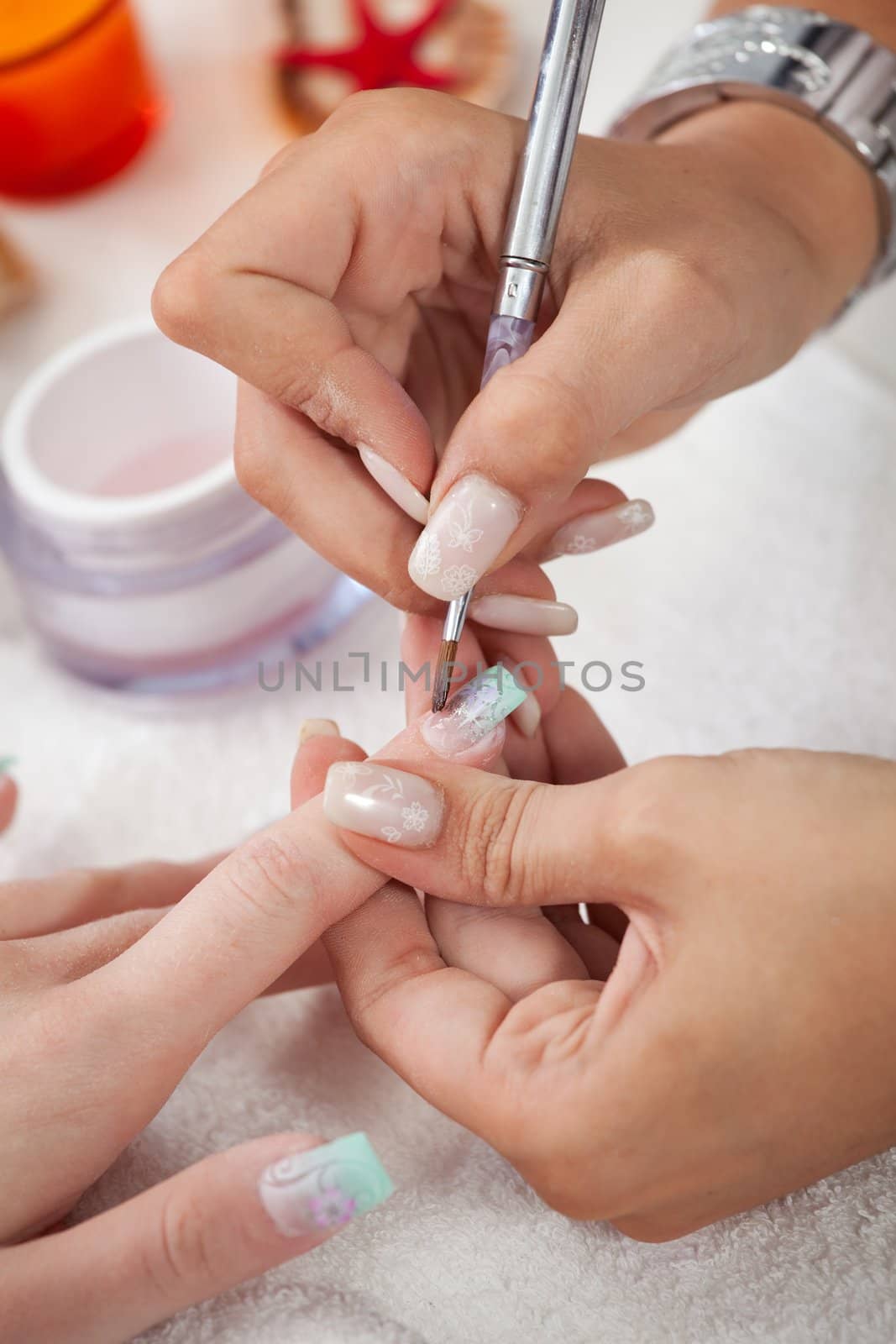 Beautician applying gel on fingernails. Close-up shot