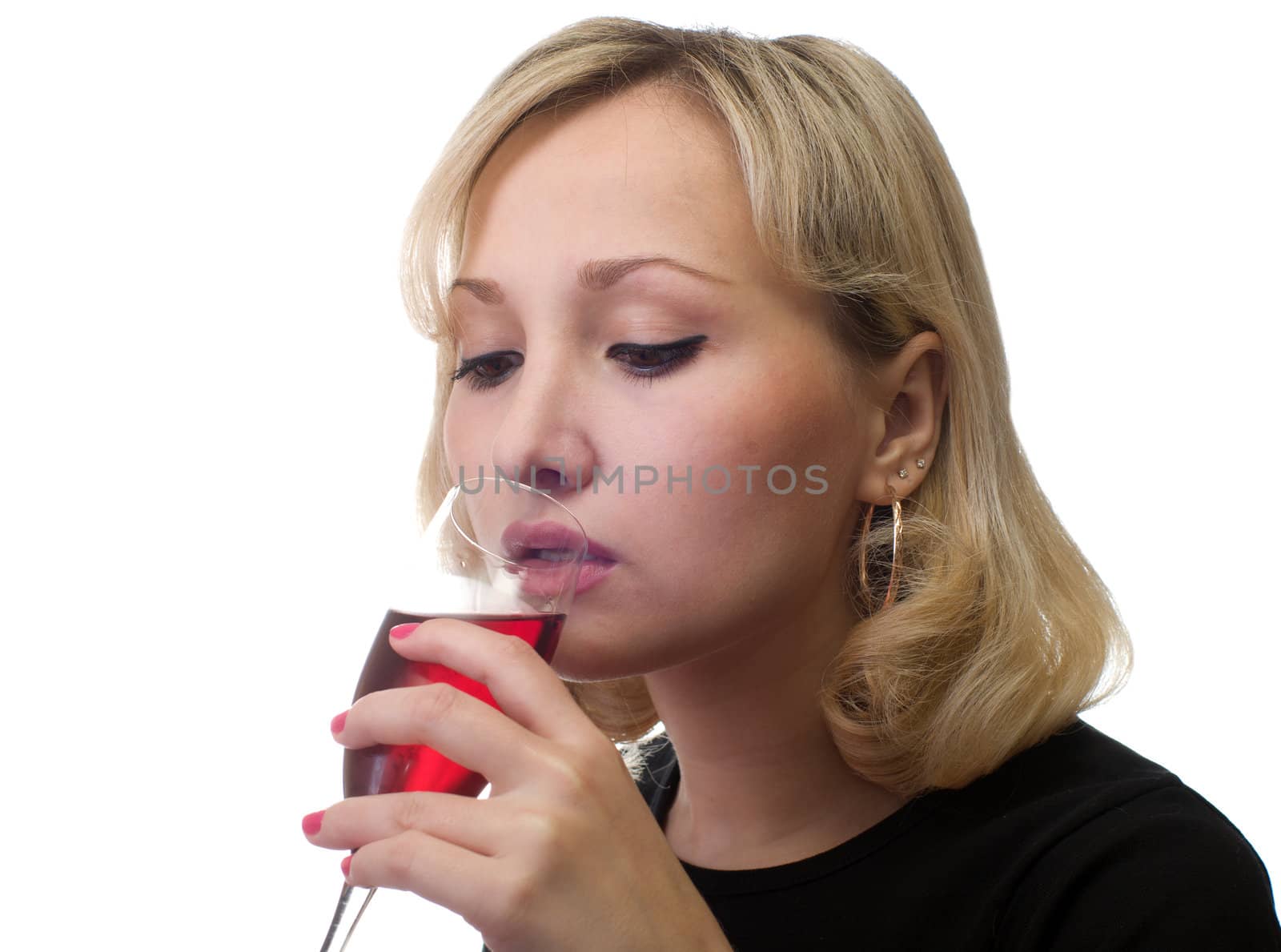 The female drinks red wine from a glass.