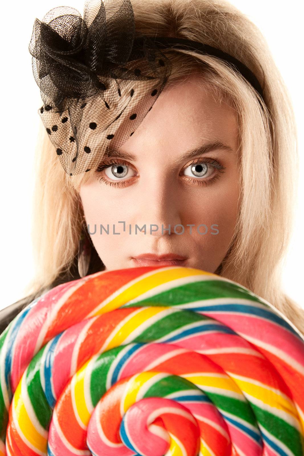 Pretty young blonde woman with large colorful lollipop
