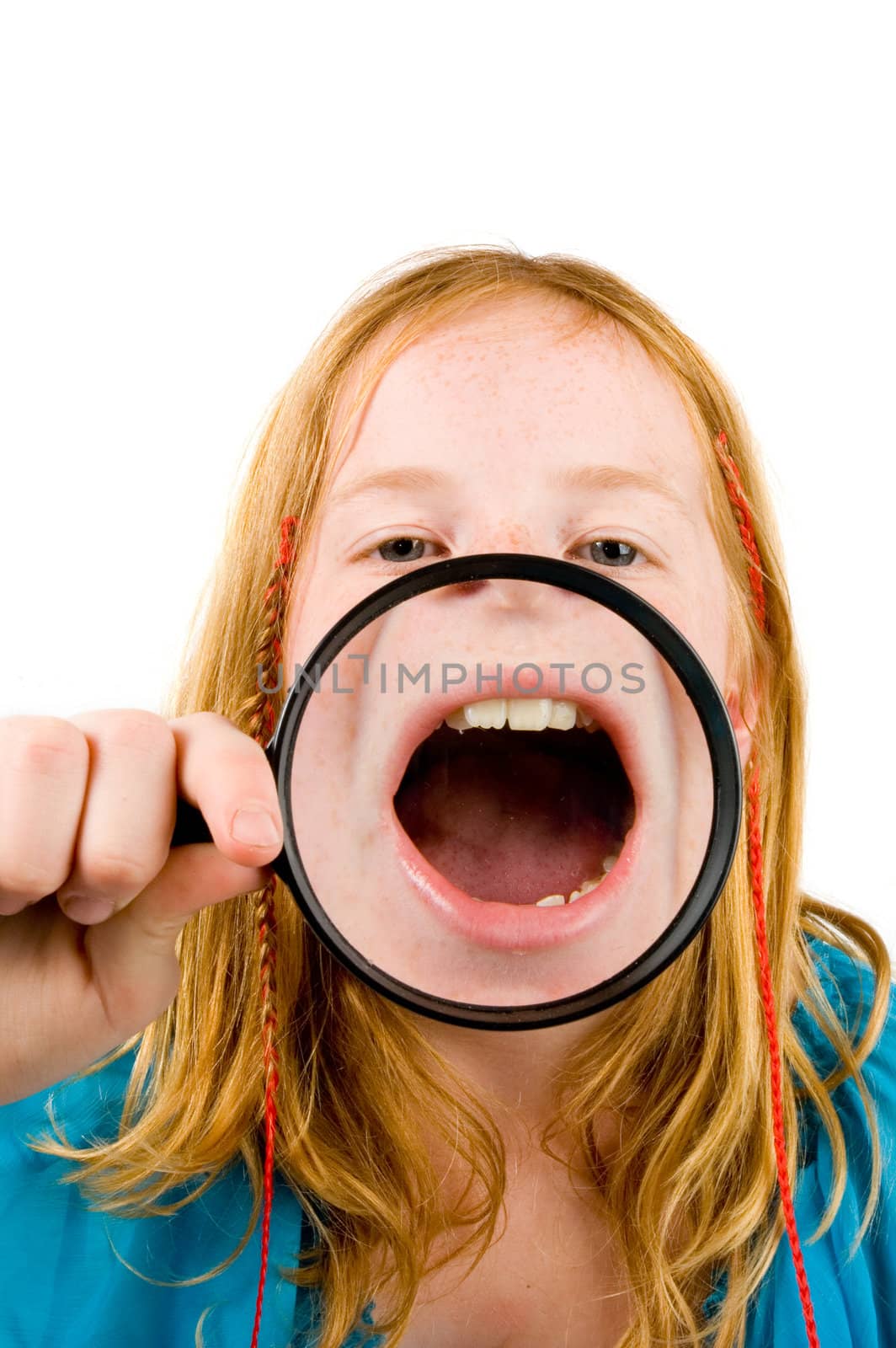 little girl is showing her mouth through a magnifying-glass over white