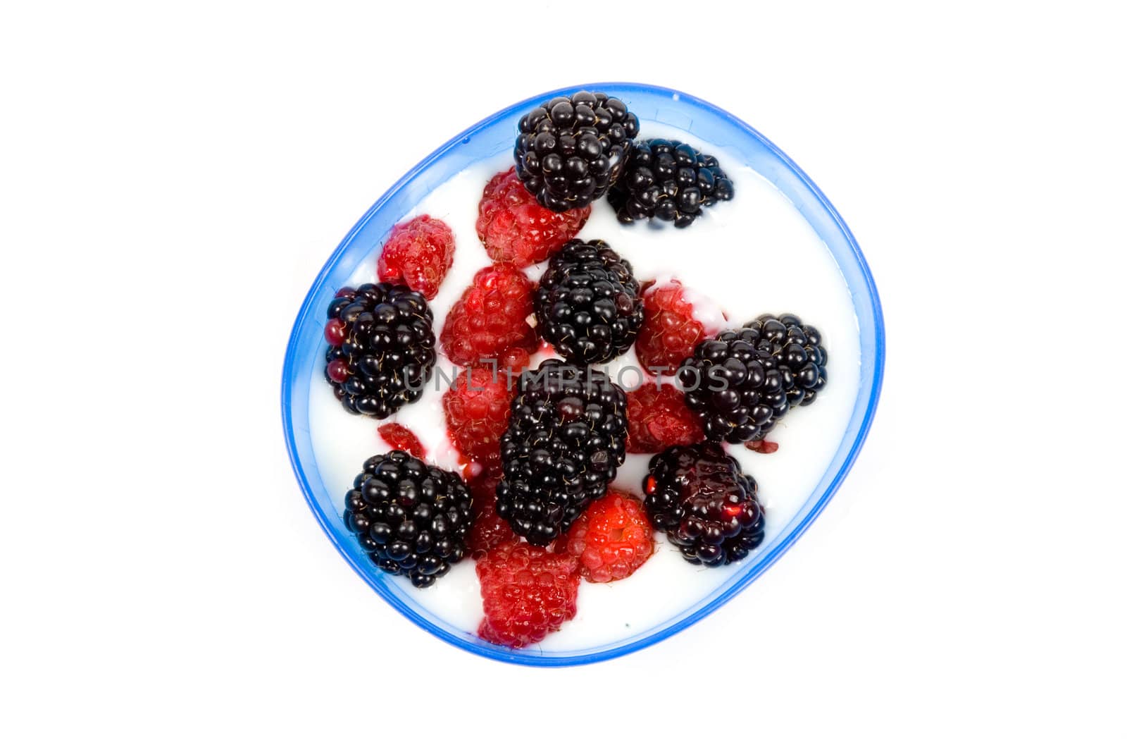 bowl youhurt with raspberries and blackberries over white