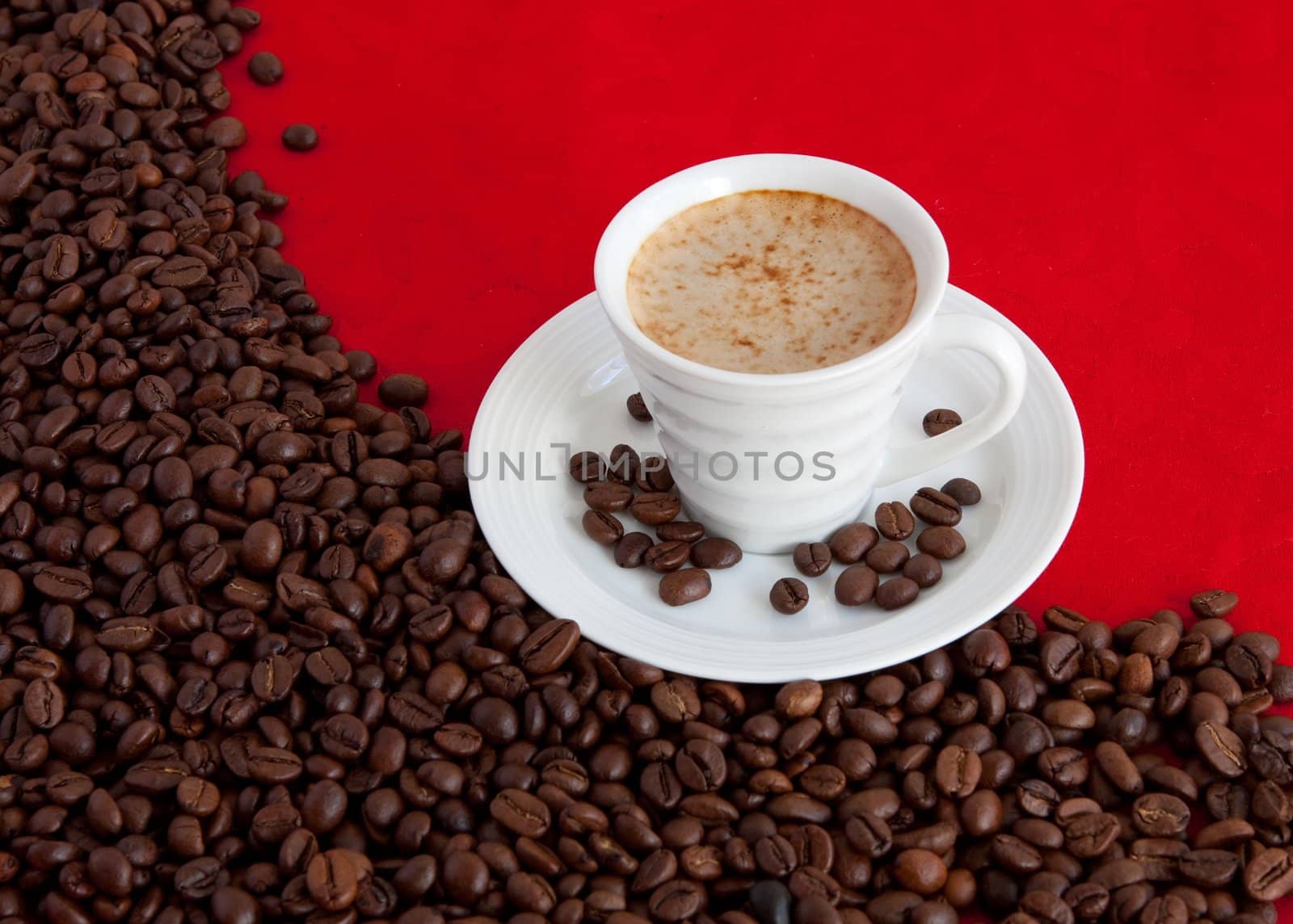 cup with coffee and grain expressed on red background