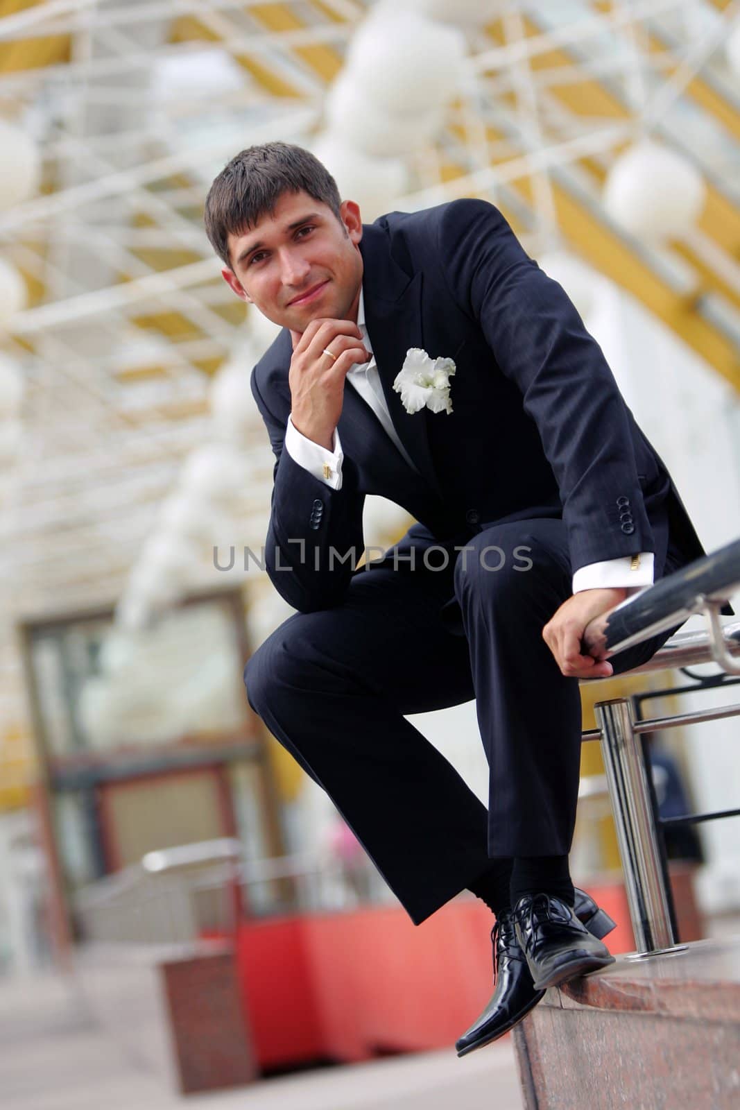 Full length portrait of handsome smiling young groom on wedding day.