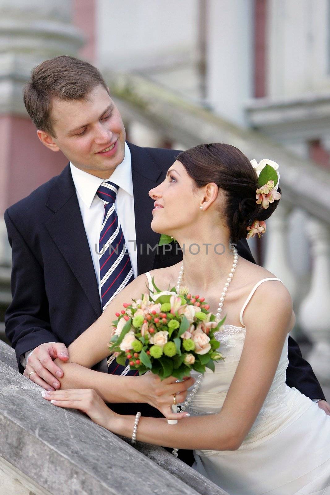 Happy newlywed couple looking lovingly at each other outdoors.