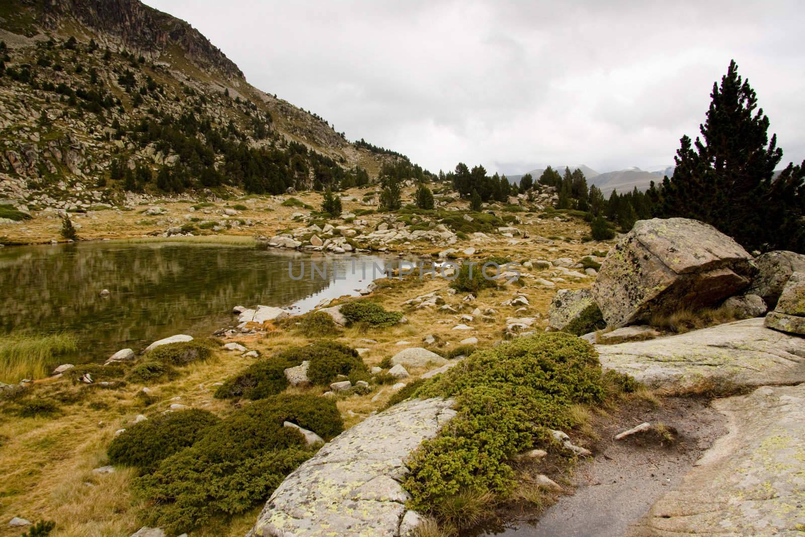 Rainy autumn day in Pyrenees mountain in Andorra.View on  small lake.