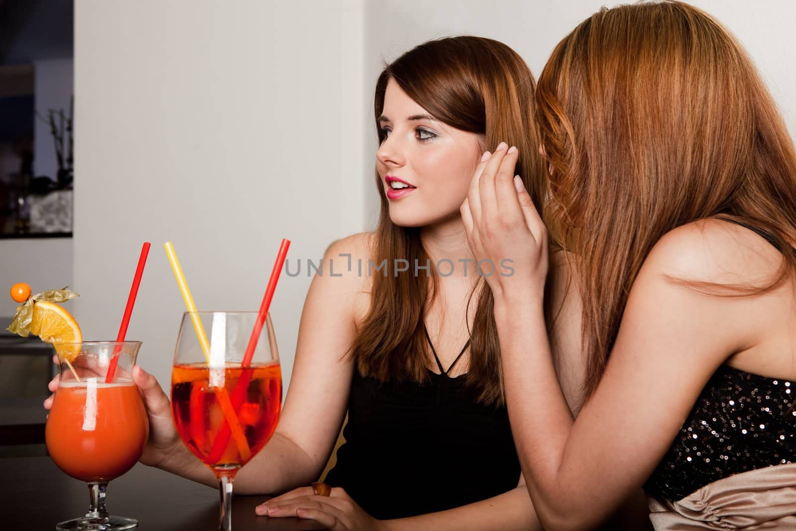 Young girls talking gossips at the bar/restaurant/nightclub