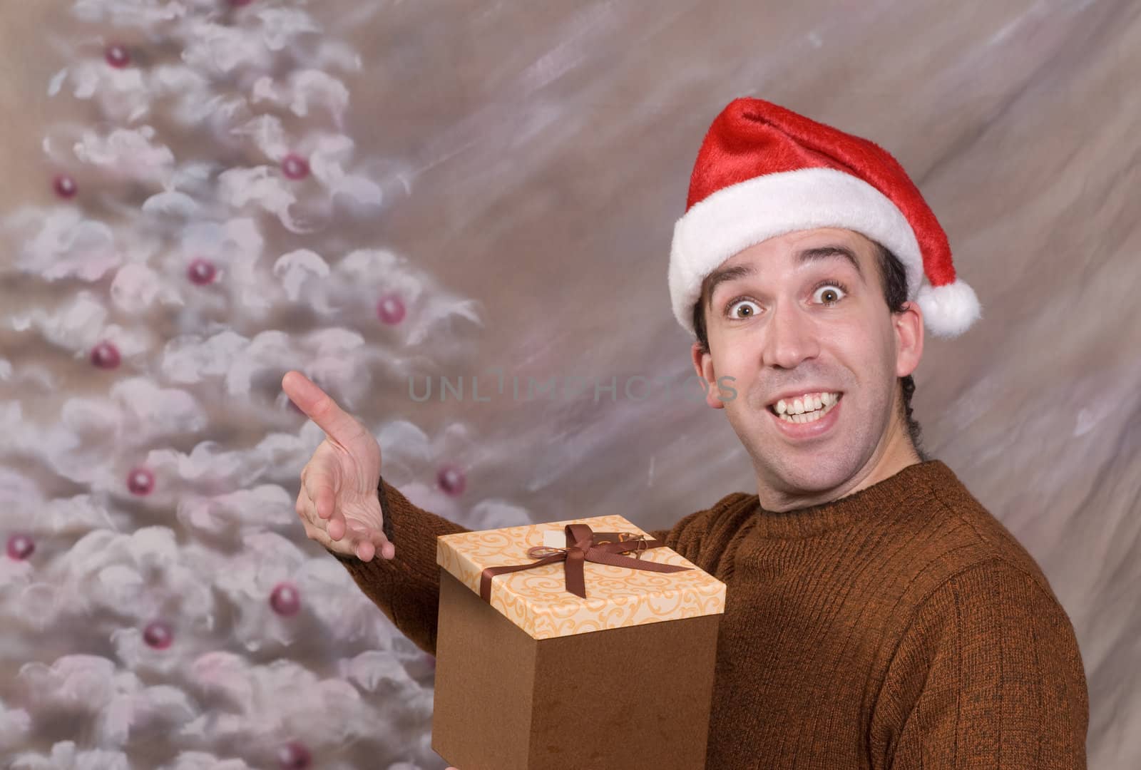 A young man holding a Christmas gift and smiling