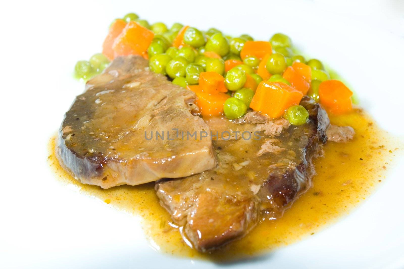 Roast beef with vegetables on white dish