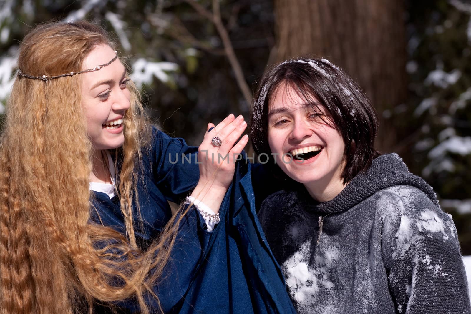 Two ladies in medieval dresses in winter forest
