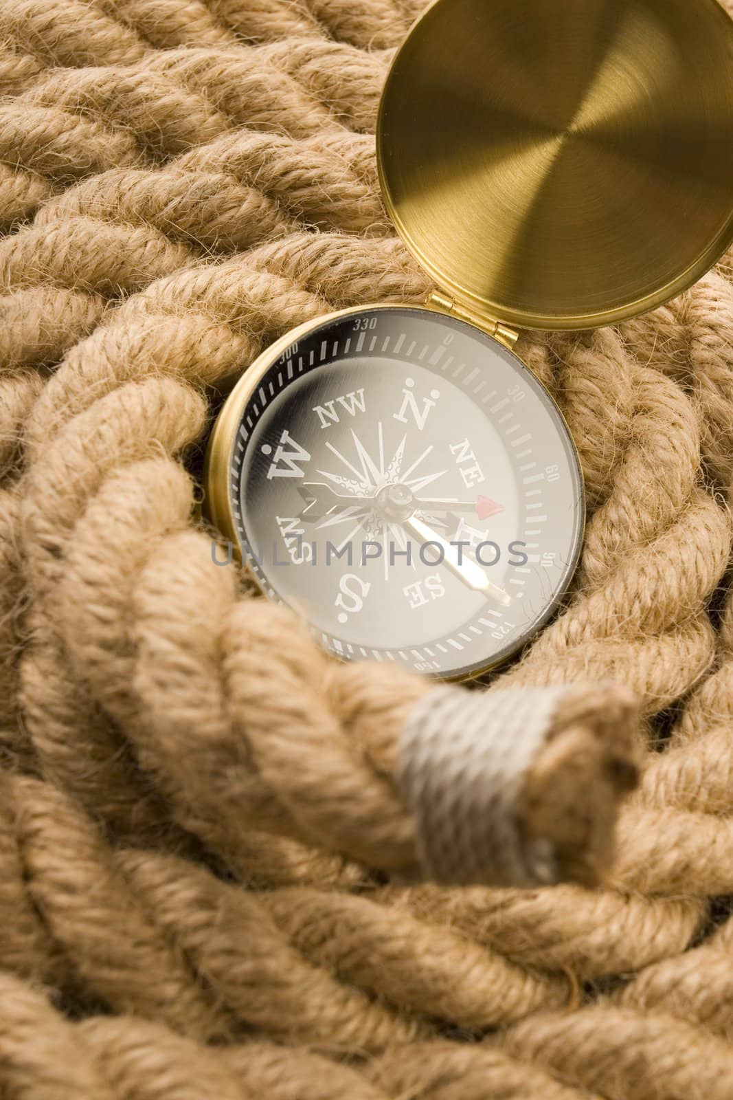 A beautiful golden compass on an old rope