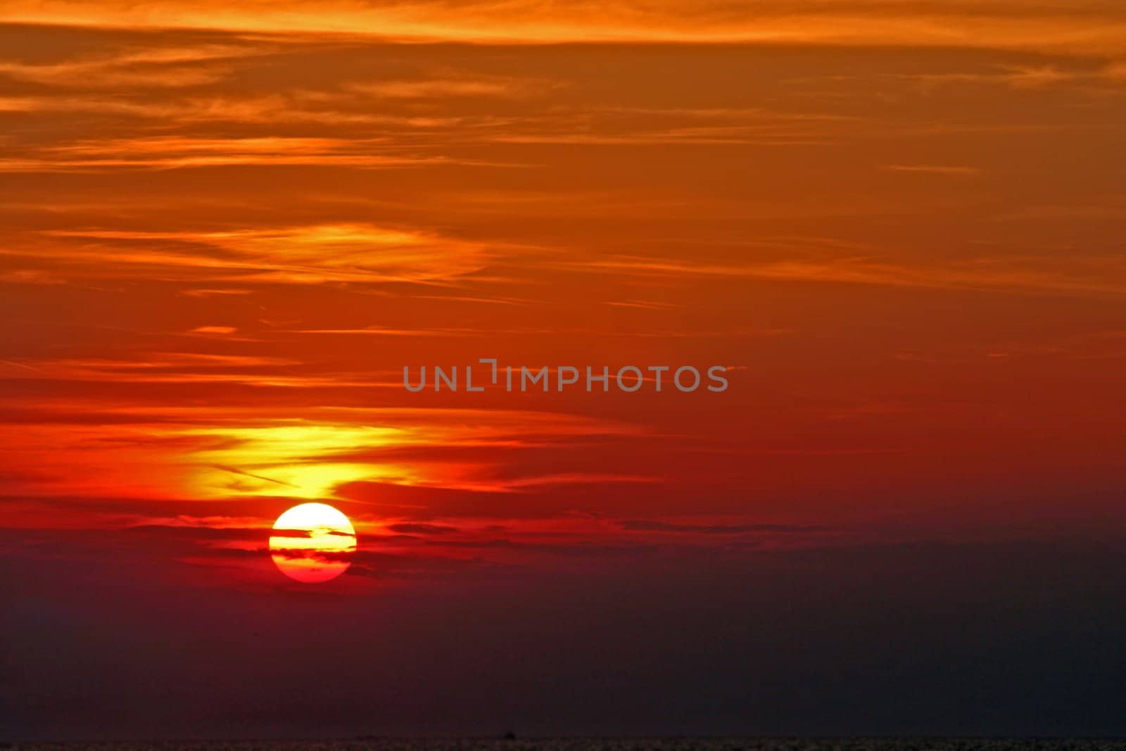 Sun setting over the sea with clouds