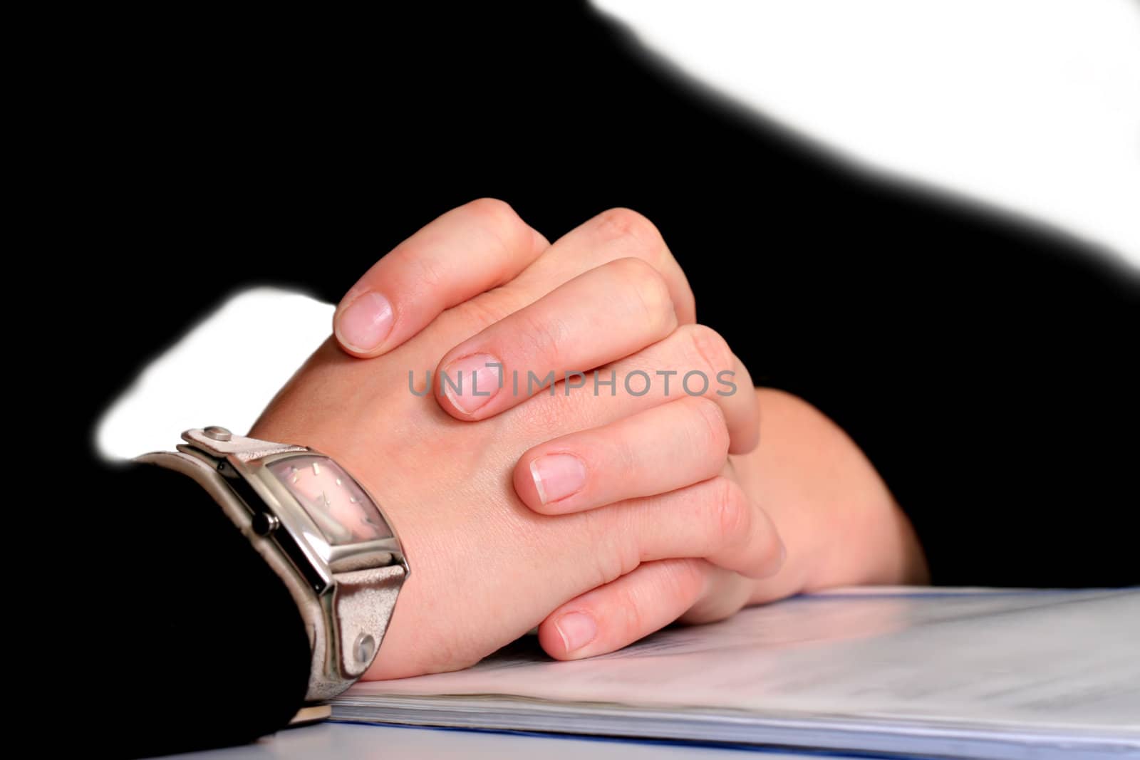 Crossed hands on book with watch