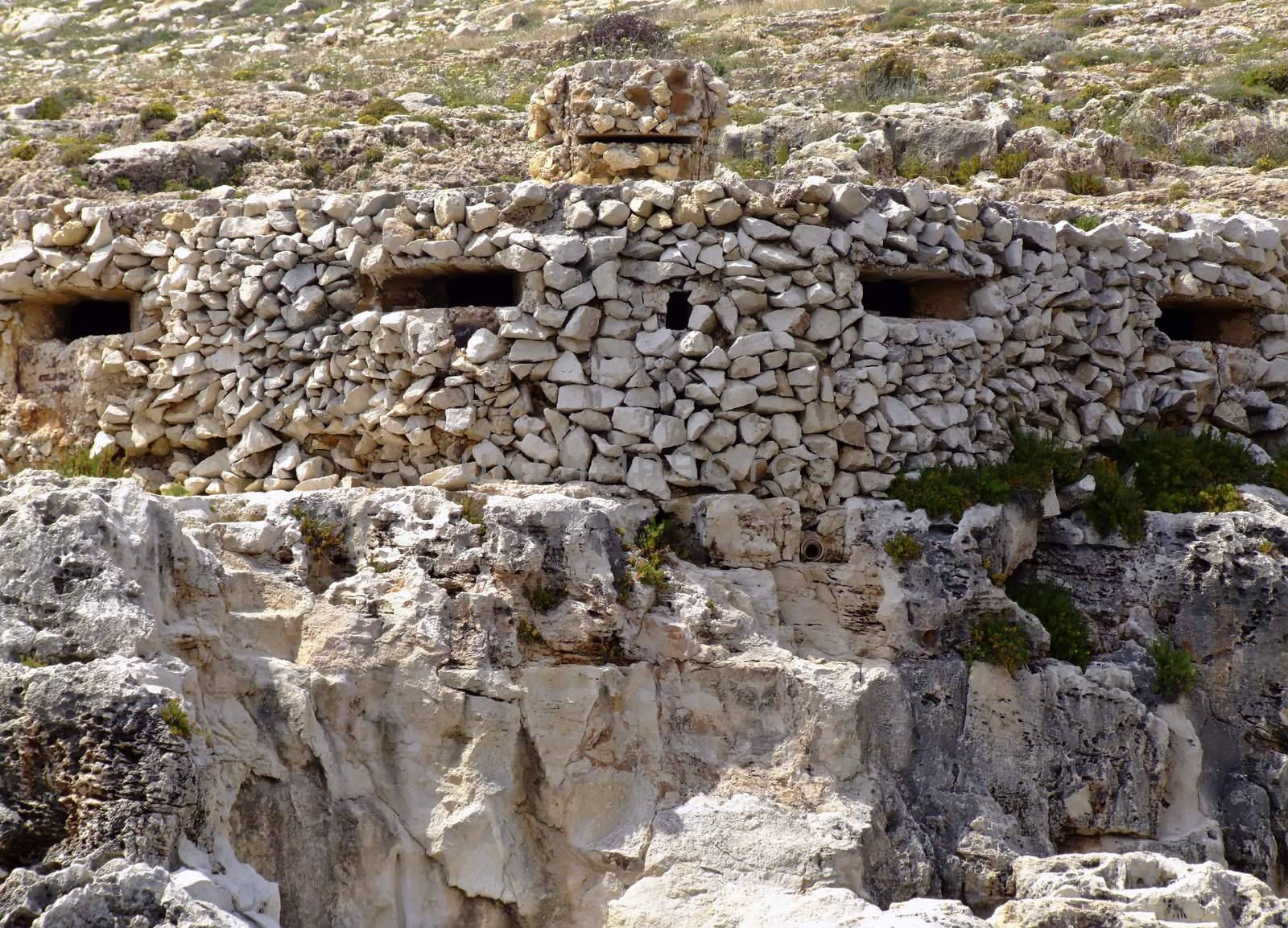 Typical WWII pill-box, or machine-gun turret, used for coastline defence in Malta. Note the clever use of camouflage by using similar rocks from the surrounding environment to build the post.