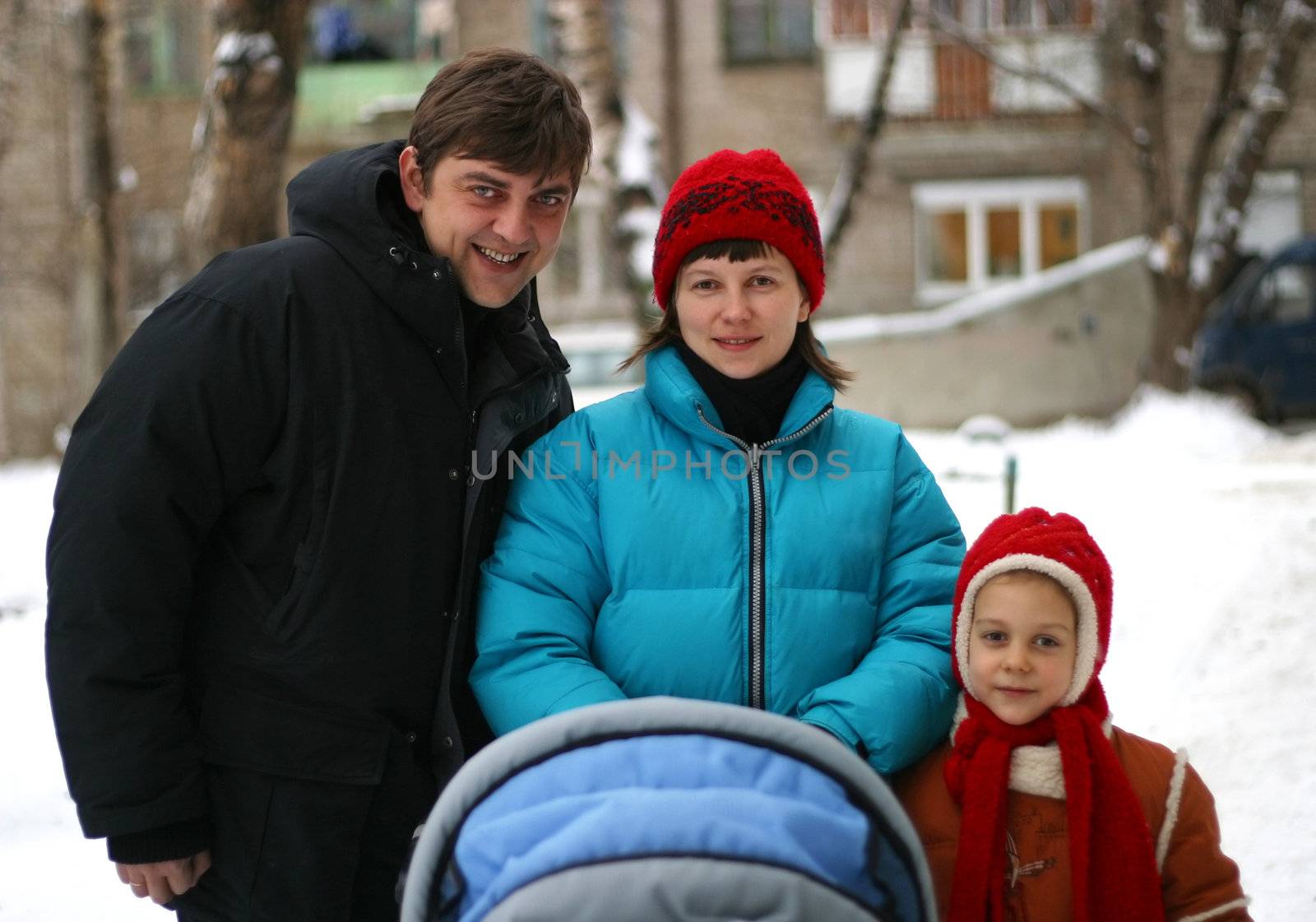 Father, mother, the daughter and newborn in stroller