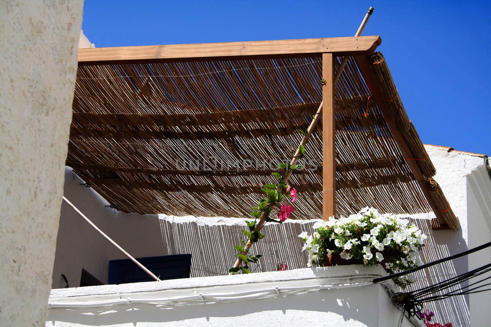 a white and flowered balcony of a summer house covered and fresh.
