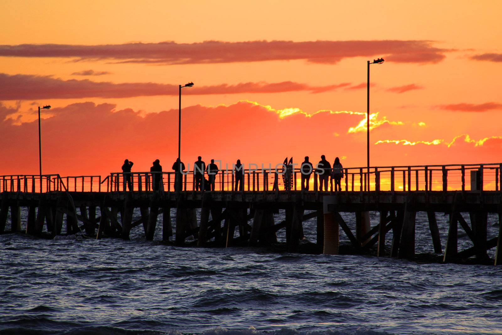 People on Jetty watching Sunset.  Semaphore Beach, Adelaide, Australia.