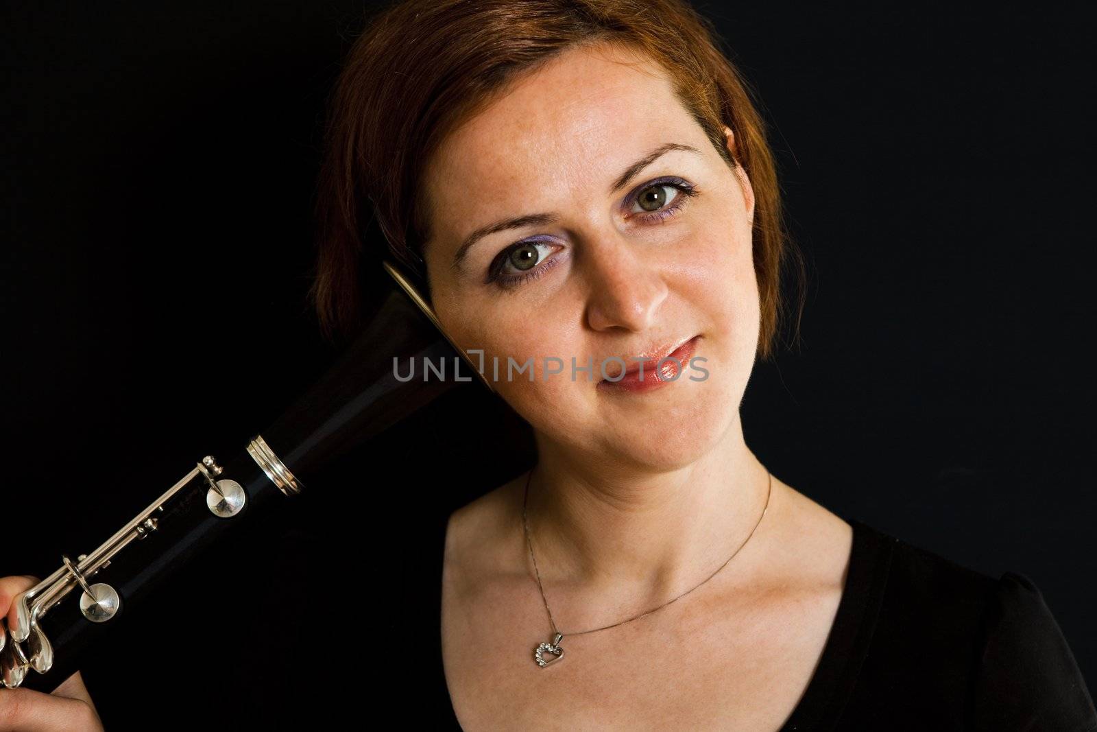 Cheerful clarinetist women listening to clarinet. Close-up shot