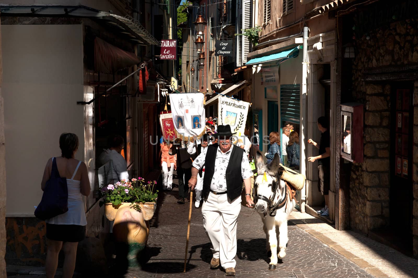 Man leads a donkey through aNTIBES, 
fRANCE, in a laborday march