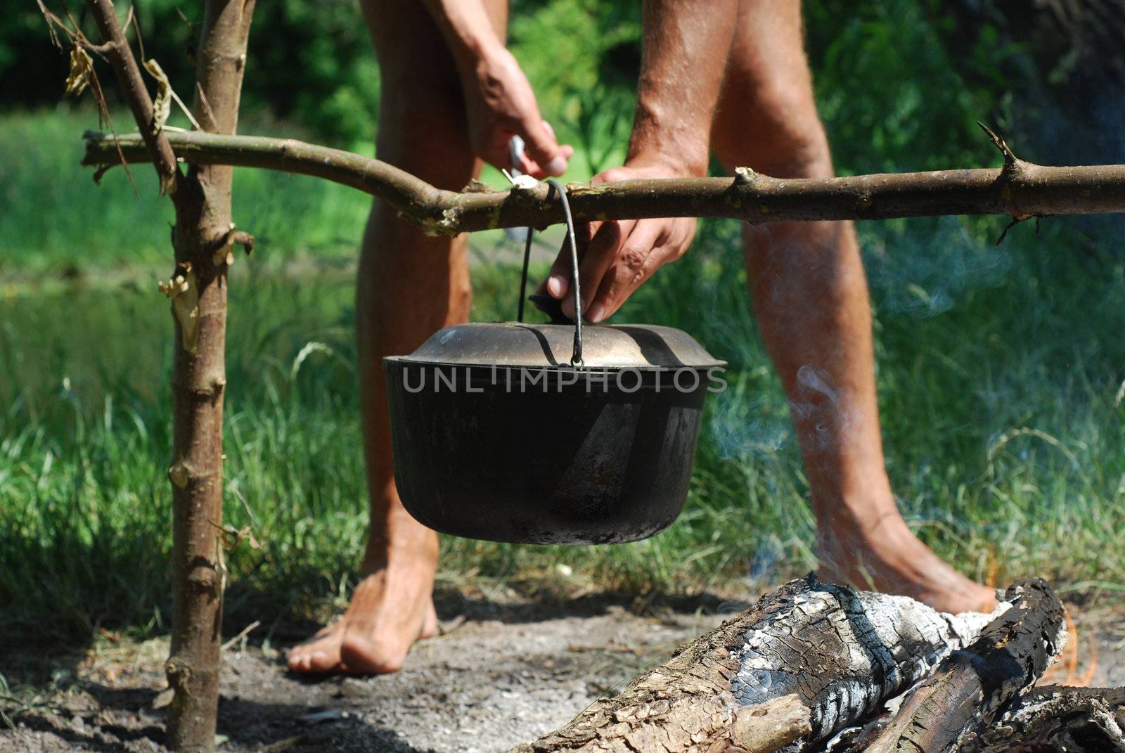 man cooking meal in a tourist pot