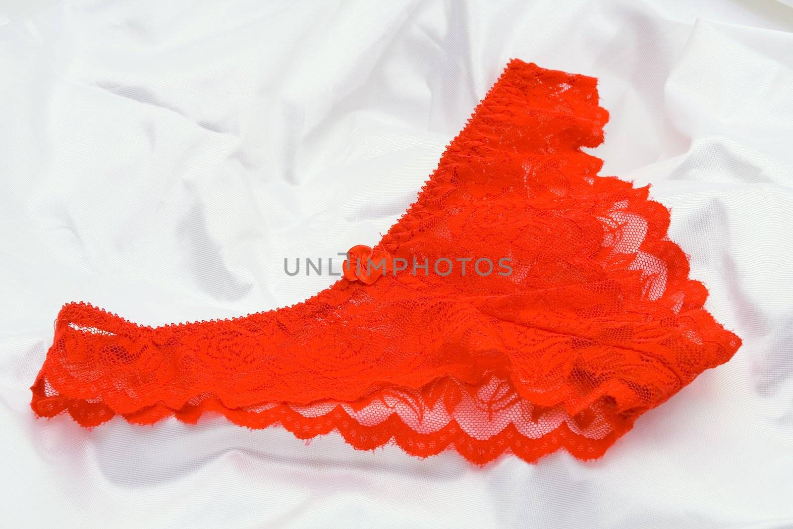 Red Women's elegant and sexy panties, lying on a white cloth