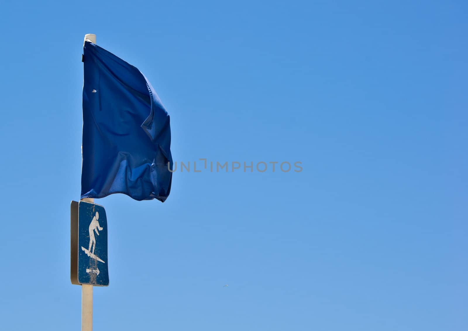 blue flag on the beach to show surfing area