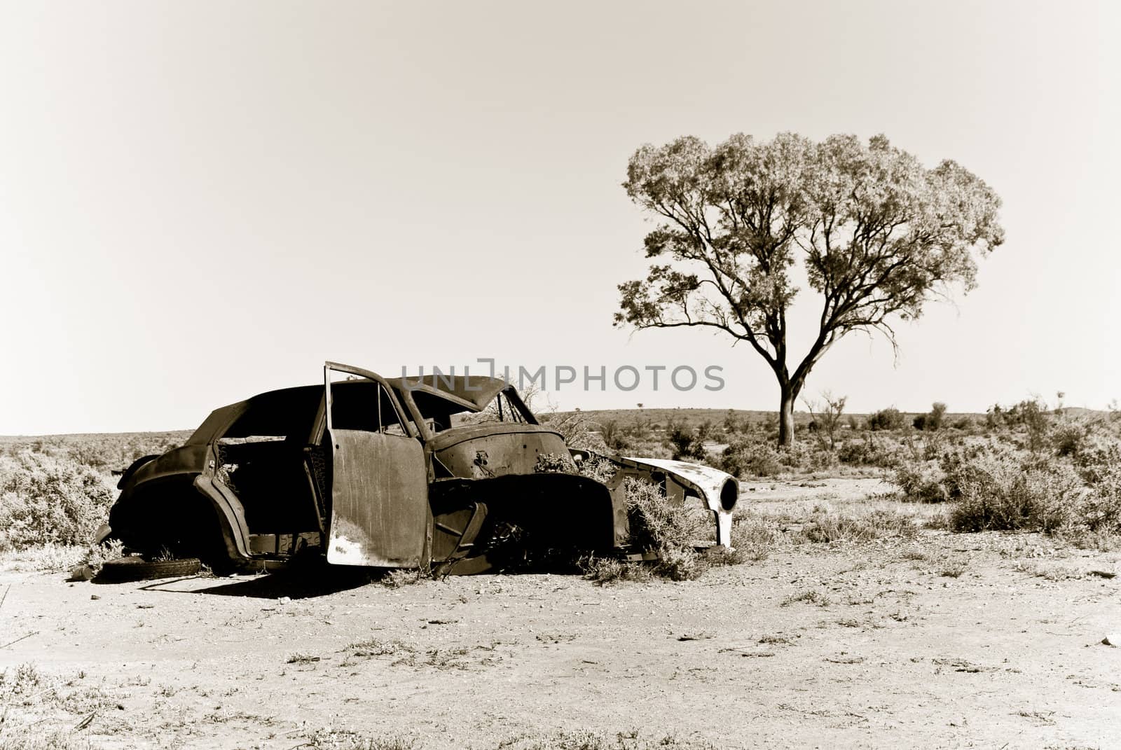 an old car rusts away in the hot australian desert